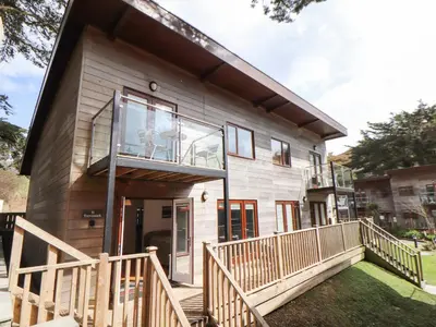 a house with a large window and a balcony at 11 Towan Valley in Truro