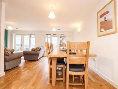 a dining room and living room with a table and chairs at 11 Towan Valley in Truro