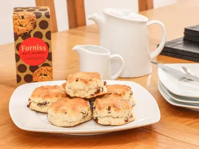 a plate of biscuits on a table with a box of cookies at 11 Towan Valley in Truro