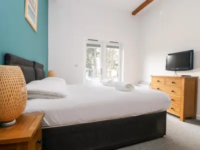 a bedroom with a large bed and a television at 11 Towan Valley in Truro