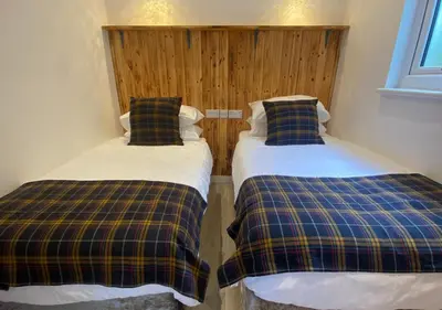 two beds sitting next to each other in a room at Minimoor Lodge in Scorrier