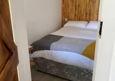a small bedroom with a bed in a room at Minimoor Lodge in Scorrier