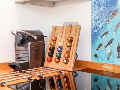 a wooden spice rack next to a radio and a painting at Rosewarrick Cottage in Bodmin
