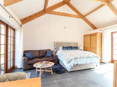 a bedroom with a bed and a couch at Rosewarrick Cottage in Bodmin