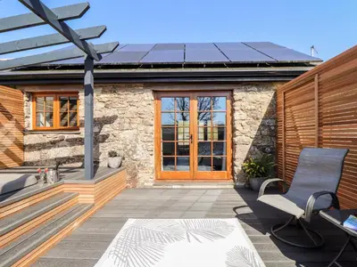 a house with a solar roof on a patio at Rosewarrick Cottage in Bodmin