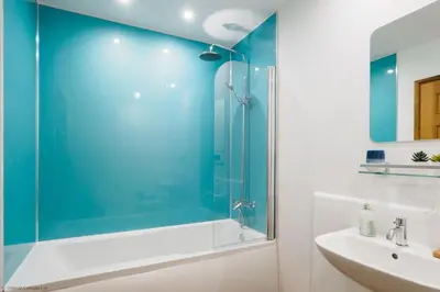 a bathroom with a glass shower and a sink at Budock Cottage in Mawnan