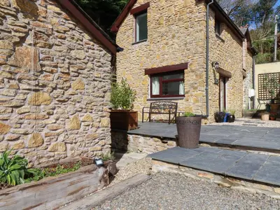 a stone house with a stone wall at Blue Bell Cottage in St Austell