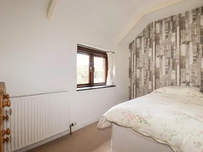 a bedroom with a bed and a window at Blue Bell Cottage in St Austell