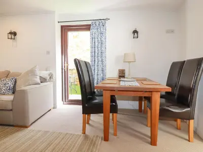 a living room with a table and chairs and a couch at Blue Bell Cottage in St Austell