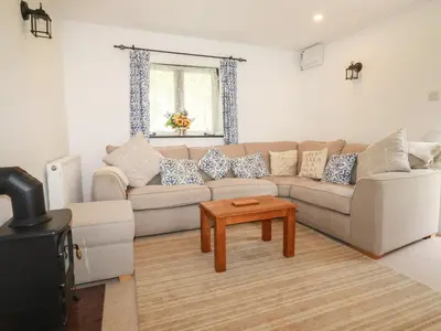 a living room with a couch and a table at Blue Bell Cottage in St Austell