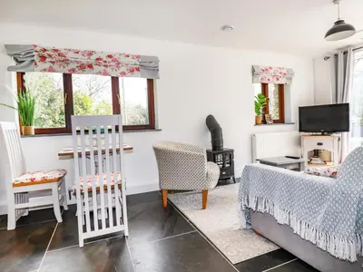 a living room with a couch and chairs at Rose Bud Cottage in St Austell