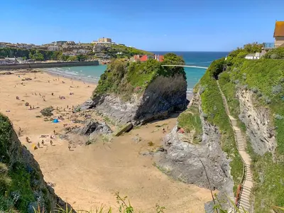 a group of people on a beach next to the ocean at Summer Breeze in Newquay