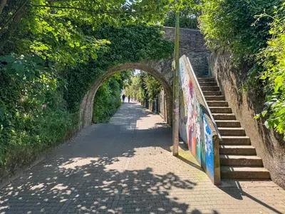 an alley way with an archway and stairs on a street at Summer Breeze in Newquay