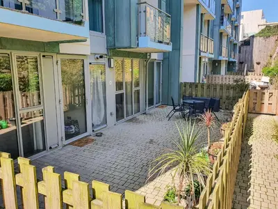a house with a fence and a patio at Apartment 4, Zinc in Newquay