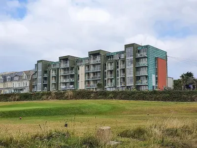 a large apartment building with a field in front of it at Apartment 4, Zinc in Newquay