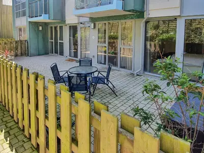 a patio with a table and chairs in front of a building at Apartment 4, Zinc in Newquay