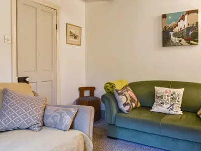 a living room with a green couch and a chair at The Old Sweetshop in Par