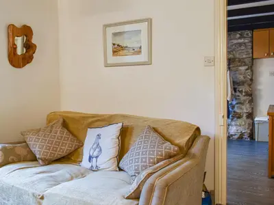 a couch with pillows on it in a living room at The Old Sweetshop in Par