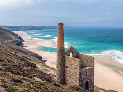 an old building on a hill next to a beach at Sage Cottage in Truro