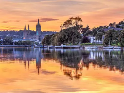 a view of a city from the water at sunset at Sage Cottage in Truro