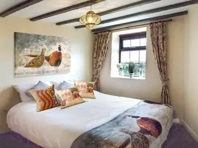 a bedroom with a bed with a picture of chickens on it at Sage Cottage in Truro