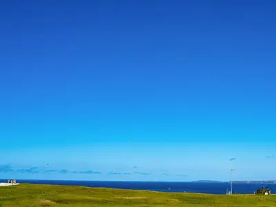 a view of the ocean from a grassy field at Penthouse 47 Zinc in Newquay