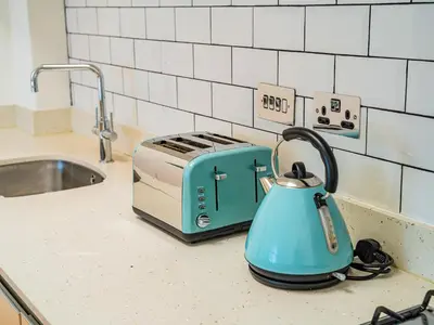 a blue tea kettle sitting on a counter next to a toaster at Penthouse 47 Zinc in Newquay
