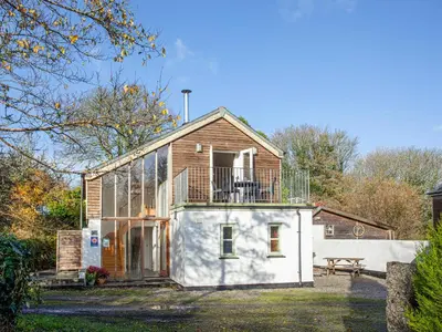 a house with a balcony on top of it at Old Dairy - Uk36514 in Germoe