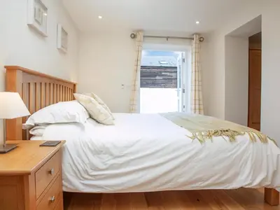 a bedroom with a large white bed and a desk at Old Dairy - Uk36514 in Germoe
