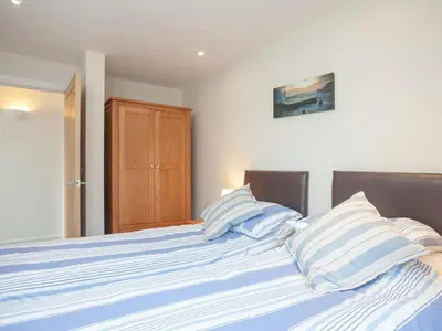a bed with blue and white striped pillows on it at Old Dairy - Uk36514 in Germoe
