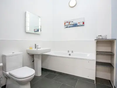 a bathroom with a toilet and a sink and a bath tub at Old Dairy - Uk36514 in Germoe