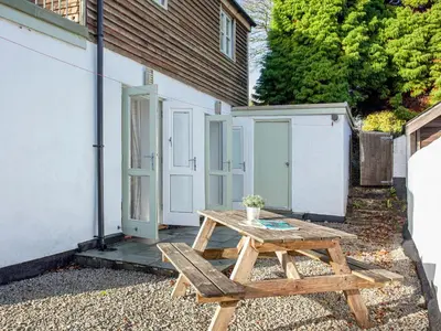 a wooden picnic table in front of a building at Old Dairy - Uk36514 in Germoe