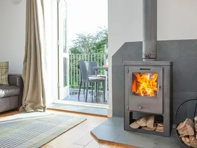 a fireplace in a living room with a stove at Old Dairy - Uk36514 in Germoe