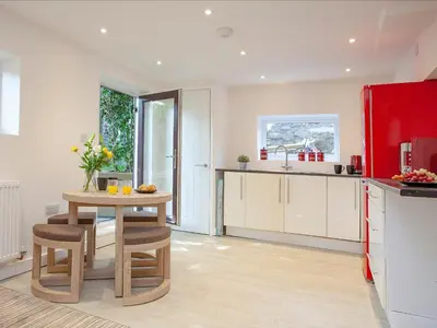 a kitchen with a table and a red refrigerator at Crofty's Celder - Uk35181 in Pool