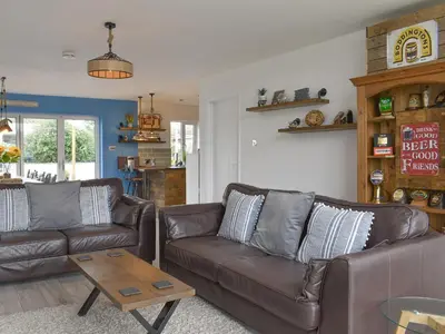 a living room with two leather couches and a coffee table at The Lily Pad in St Merryn