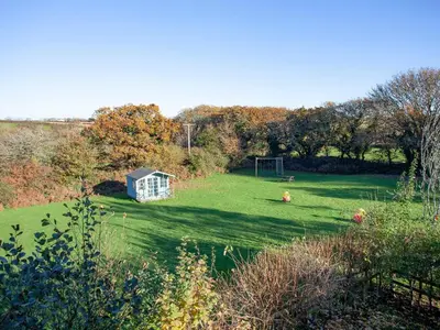 a green field with a house and a goal at The Hayloft - Uk36516 in Germoe