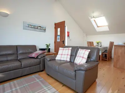 a living room with a couch and a table at The Hayloft - Uk36516 in Germoe