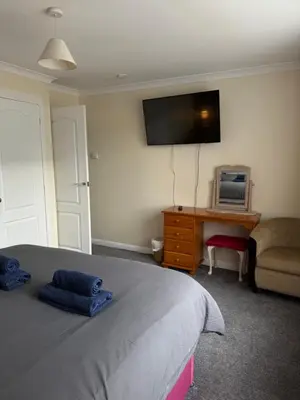 a bedroom with a bed and a desk and a tv at Apartment 11 Chester Road Newquay in Newquay