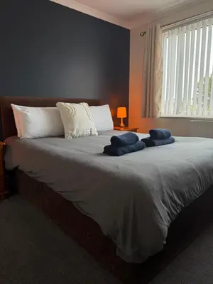 a bedroom with a large bed with two blue towels on it at Apartment 11 Chester Road Newquay in Newquay