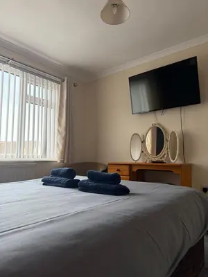 a bedroom with a large bed with two blue pillows on it at Apartment 11 Chester Road Newquay in Newquay
