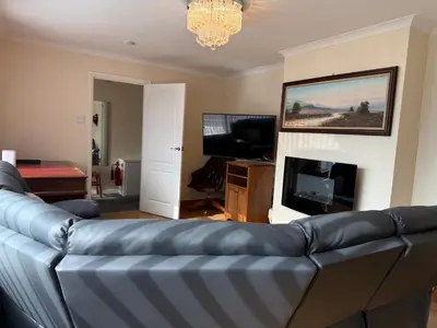 a living room with a blue couch and a television at Apartment 11 Chester Road Newquay in Newquay