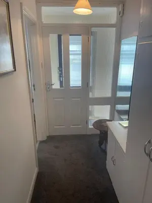 a hallway with a door and a table and a mirror at Apartment 11 Chester Road Newquay in Newquay