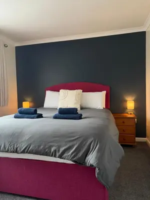 a bedroom with a large bed with a purple headboard at Apartment 11 Chester Road Newquay in Newquay