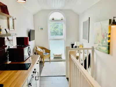 a kitchen with white walls and an arched window at 1 Bed Cottage - Sleeps 2 - Parking - Wifi in Truro
