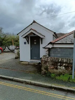 a small white building with a green door on a street at 1 Bed Cottage - Sleeps 2 - Parking - Wifi in Truro