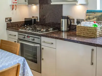 a kitchen with a stove and a counter top at Constantine Bay Cottage in Padstow