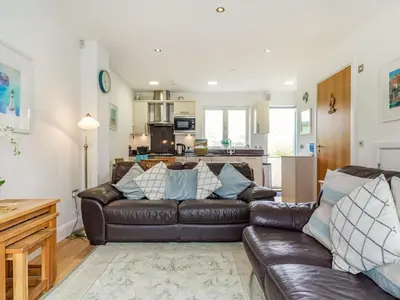 a living room with a brown leather couch at Constantine Bay Cottage in Padstow