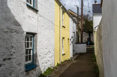 an alley between two buildings with a yellow and white building at Finest Retreats - The Hideaway - Studio Apartment in Porthleven in Porthleven
