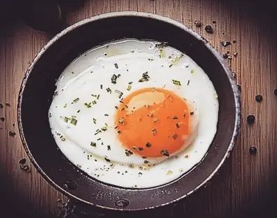 a fried egg in a pan on a wooden table at St Tudy Inn in Bodmin