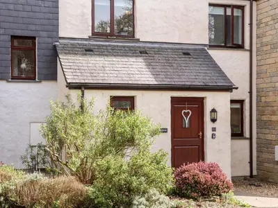 a house with a brown door with a heart on it at Charleston Cottage in Falmouth